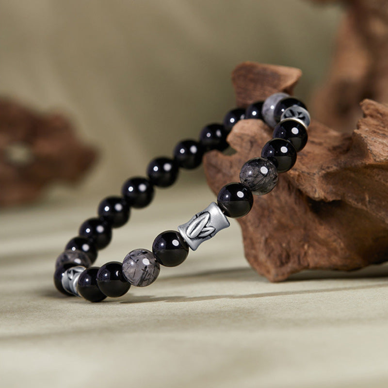 Bamboo black obsidian and black rutilated quartz bracelet on natural wood