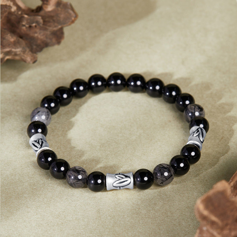 Full bamboo black obsidian bracelet on warm beige background