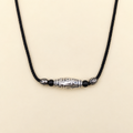 Nine-eye silver Dzi necklace on a warm cream background