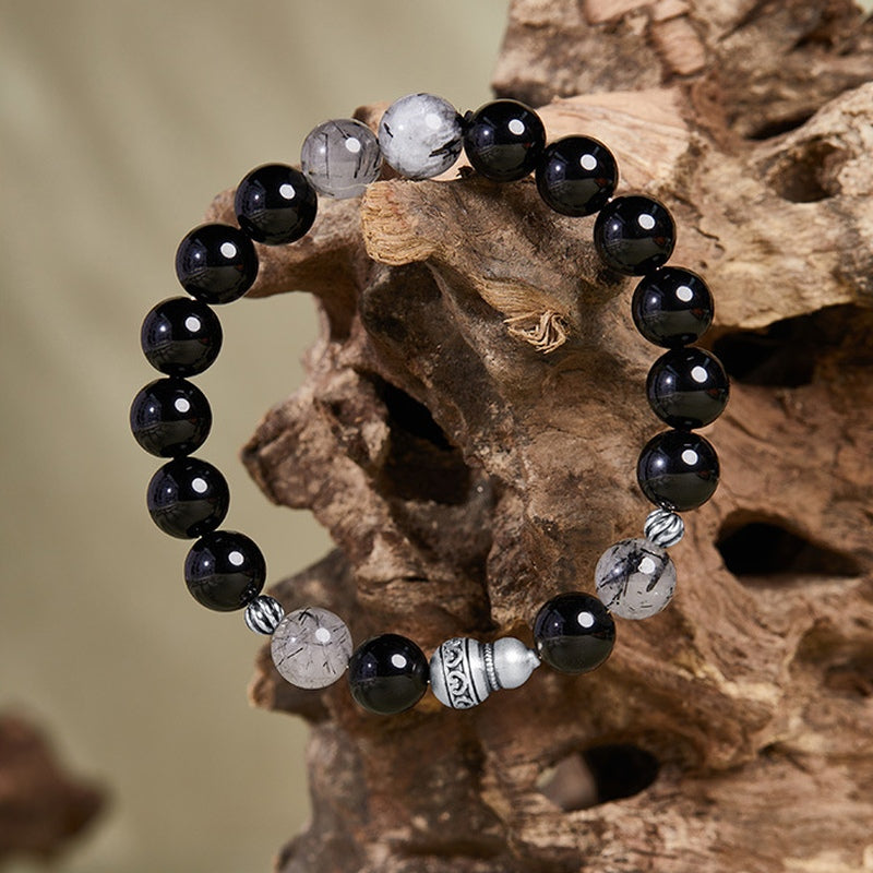 Full gourd obsidian and black inclusion quartz bracelet on wood