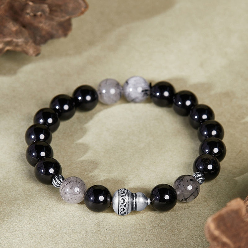Silver gourd bracelet resting on an olive-beige background