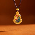 Enamel landscape gourd necklace hanging against a warm brown background