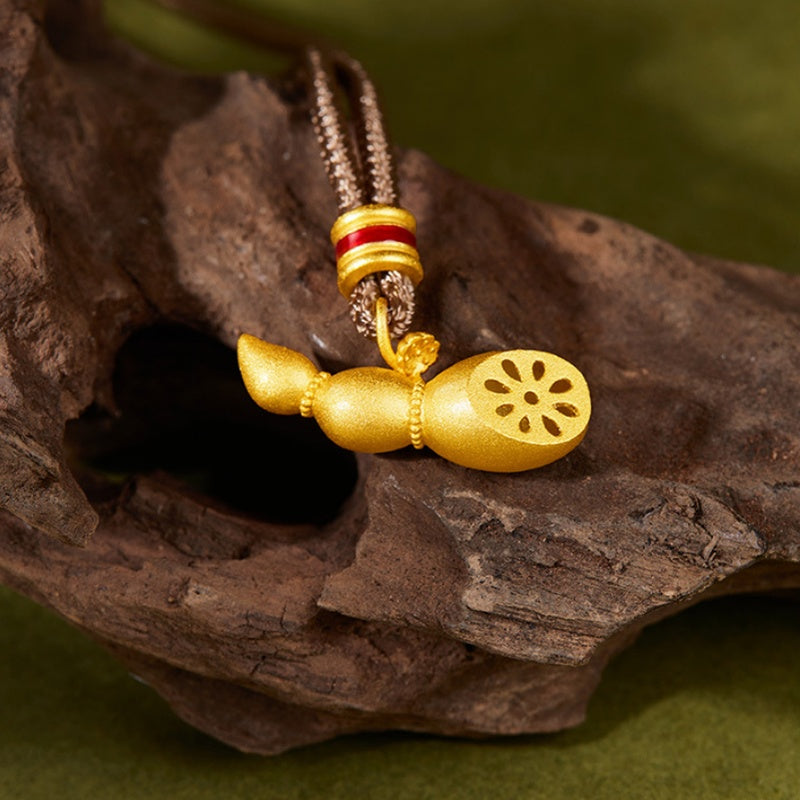 Lotus-root pendant with a red enamel cord detail resting on textured wood