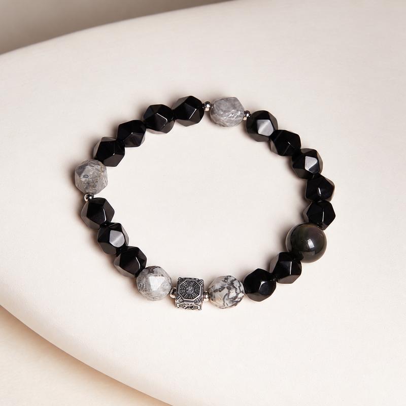 Top view of the bracelet with four gray map stones black obsidian and a Bagua detail