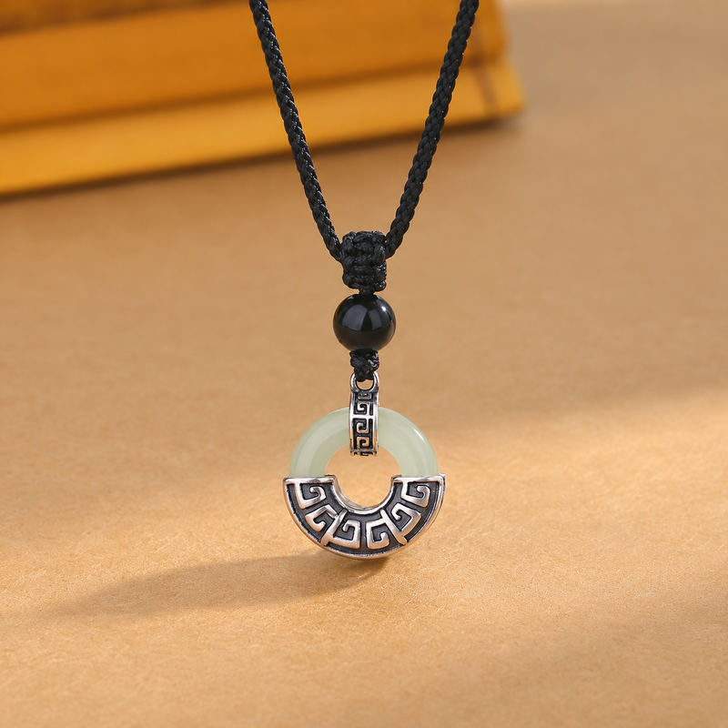 Nephrite jade peace buckle with antiqued silver setting against a warm tan background