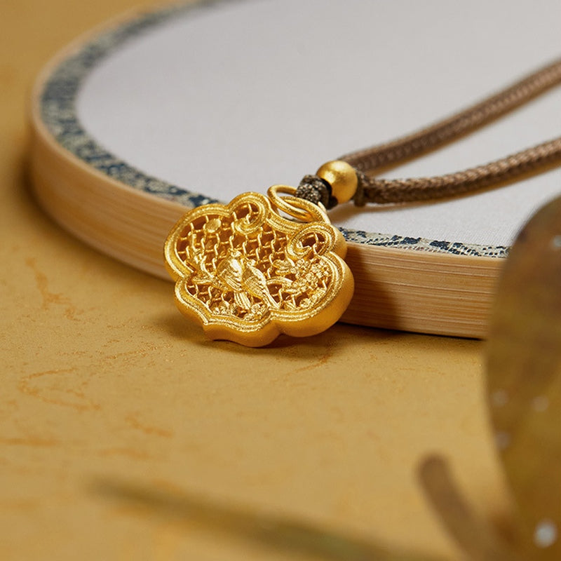 Oblique detail of the magpie ruyi lock pendant beside a fan