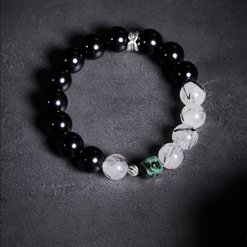 Original overhead bracelet view with green accent and feather-pattern spacer