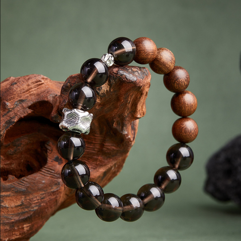 Textured silver focal piece and polished beads on a wood prop