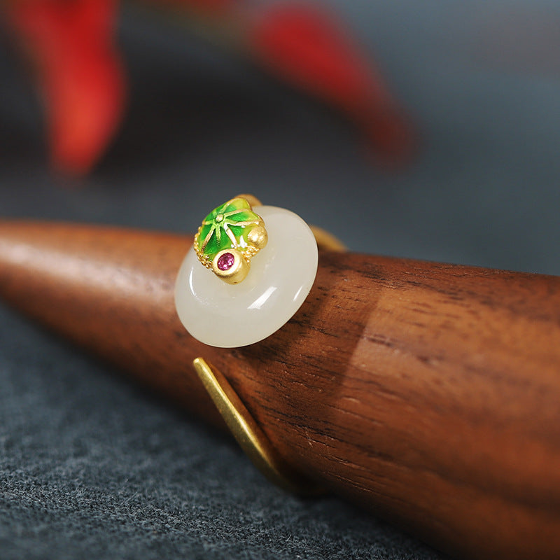 Angled close-up of the jade disc and enamel leaf