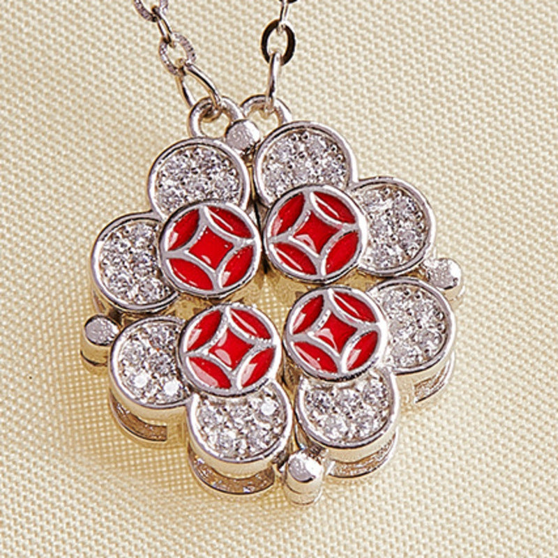 Close detail of red enamel coin motifs and cubic zirconia