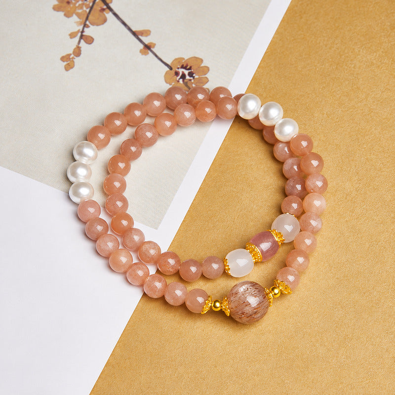 Overhead view of the double-wrap sunstone bracelet on gold paper