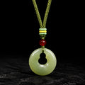 Nephrite jade gourd peace buckle pendant on a dark background