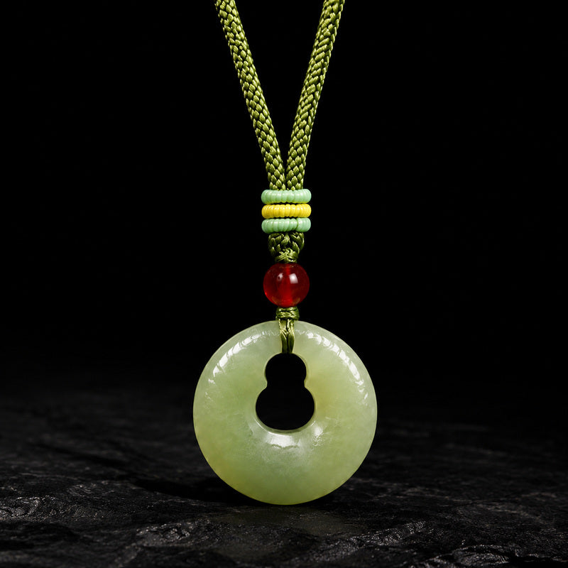 Nephrite jade gourd peace buckle pendant on a dark background