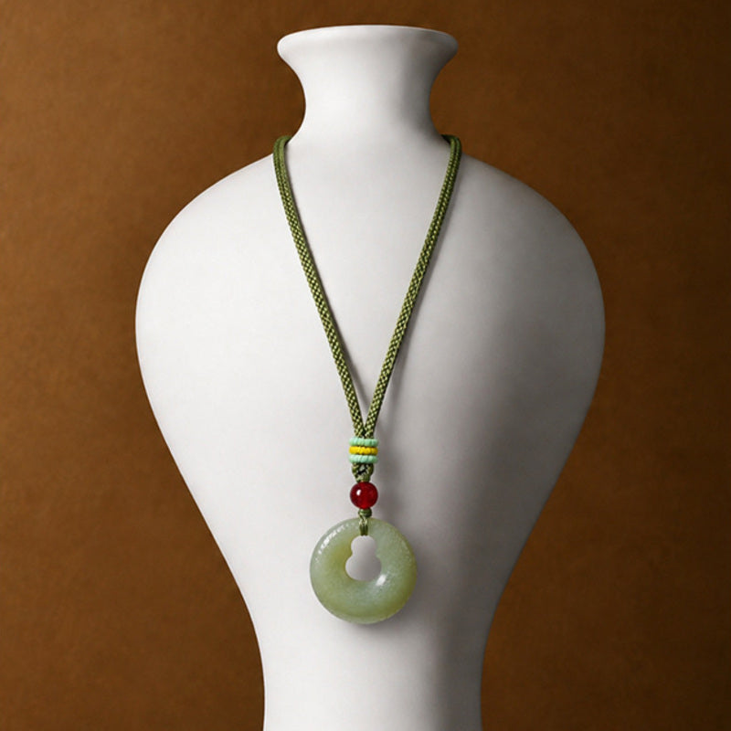 Nephrite jade gourd peace buckle pendant displayed on a necklace bust