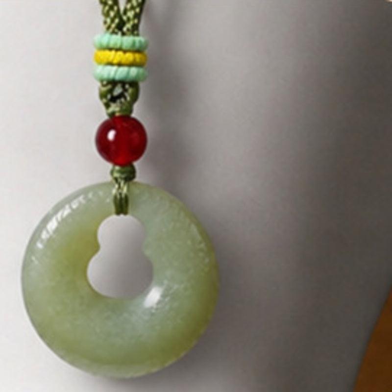 Close-up of nephrite jade gourd peace buckle and red agate bead