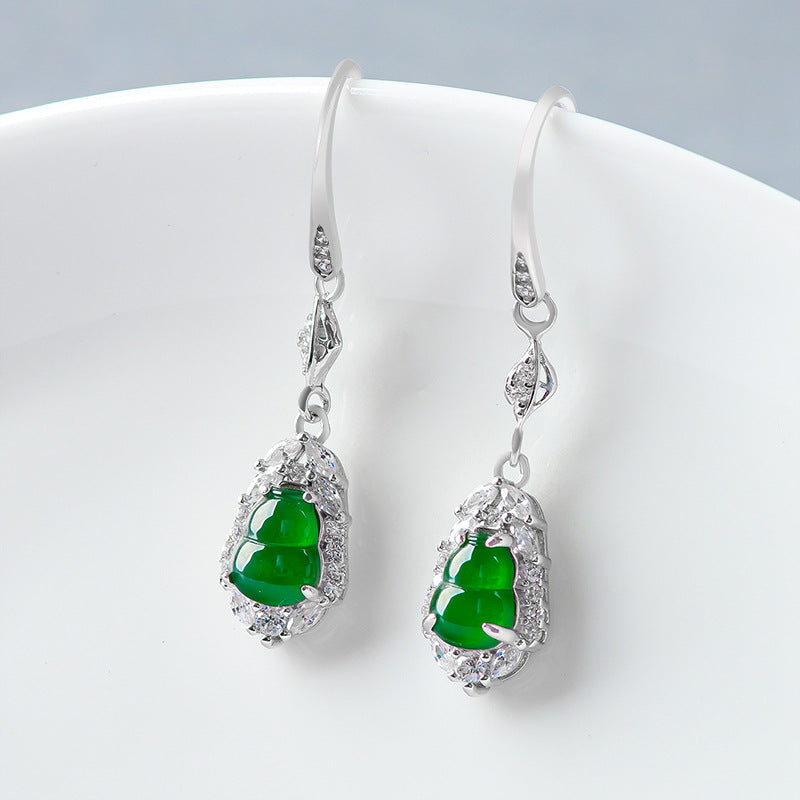 Green jade calabash wealth earrings displayed on a white jewelry stand