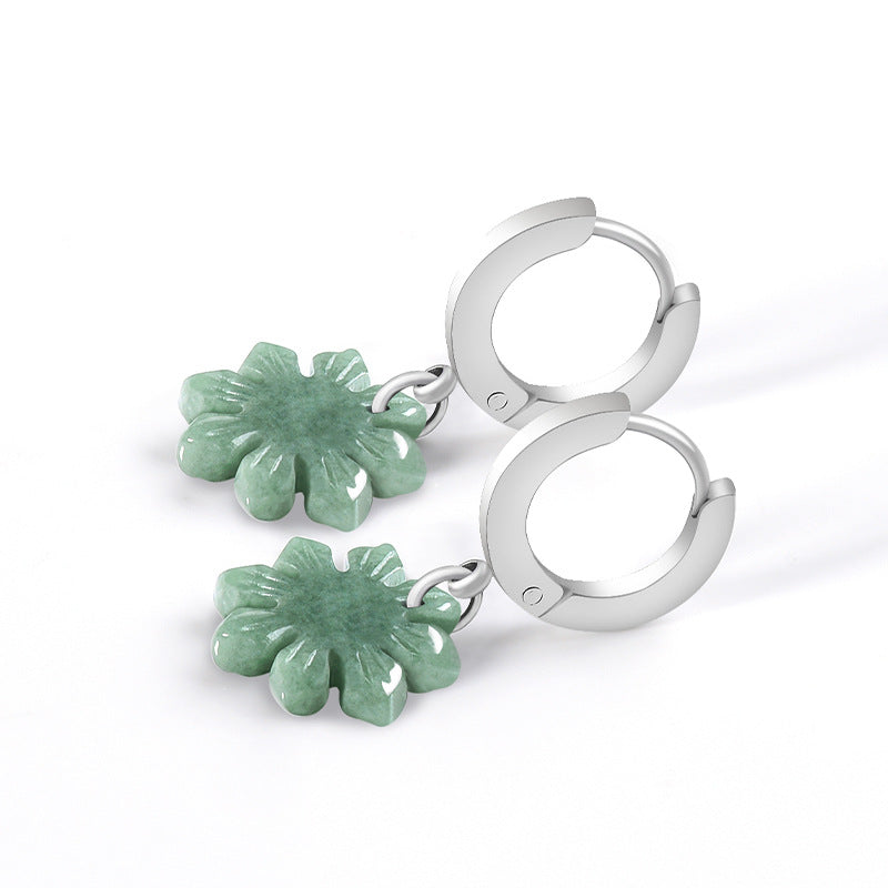 Green jade sunflower earrings lying flat beside their silver hoop closures with details visible