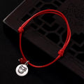 Adjustable red string bracelet with a silver Ox zodiac charm and polished red bead.