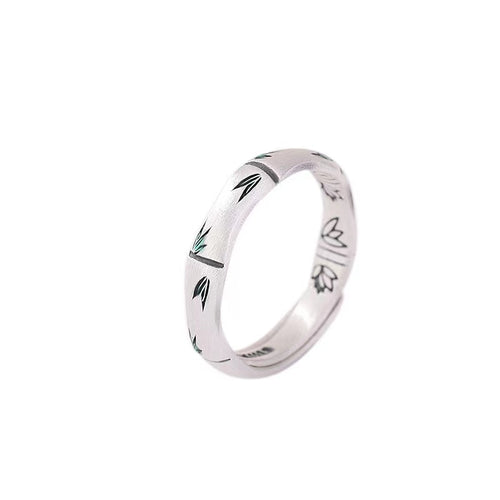 999 silver bamboo ring with small green enamel leaves isolated on a white background.