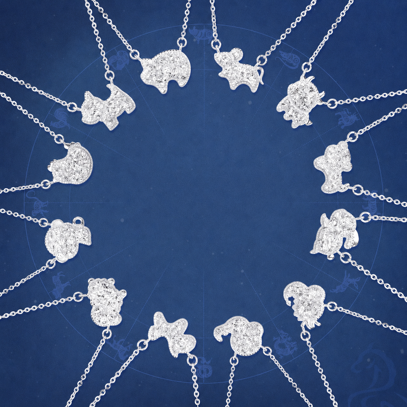 Twelve 925 silver zodiac necklaces arranged on a deep blue wheel