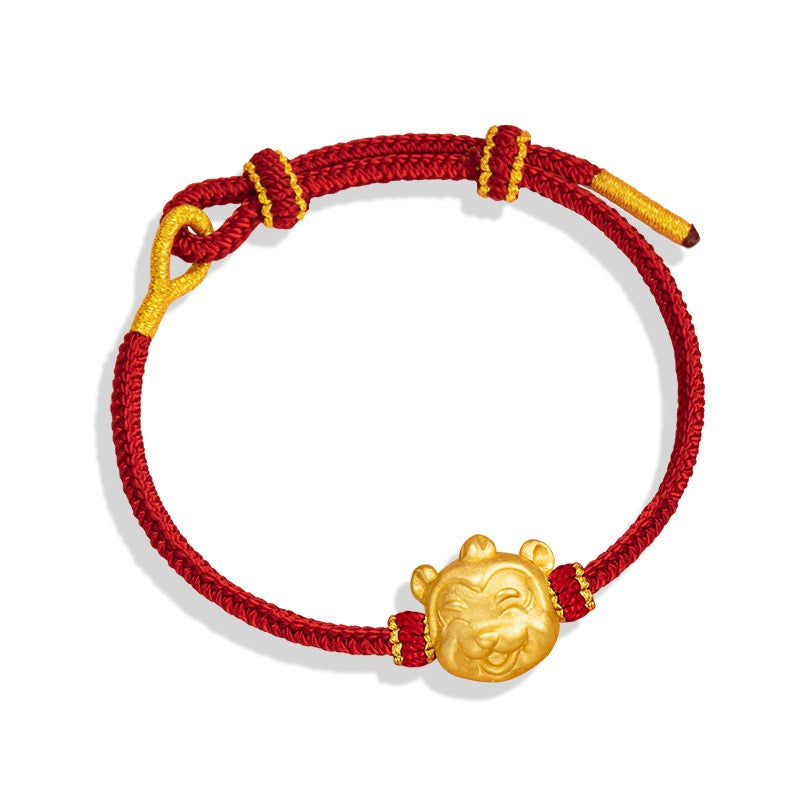 Red adjustable cord bracelet with a long-eared gold rabbit zodiac charm on white