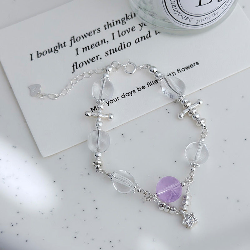 Amethyst and white crystal star bracelet on a soft gray background