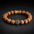 Sandalwood cloud mantra bracelet on matte dark slate