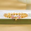 Citrine and pink strawberry quartz bamboo bracelet on a green book