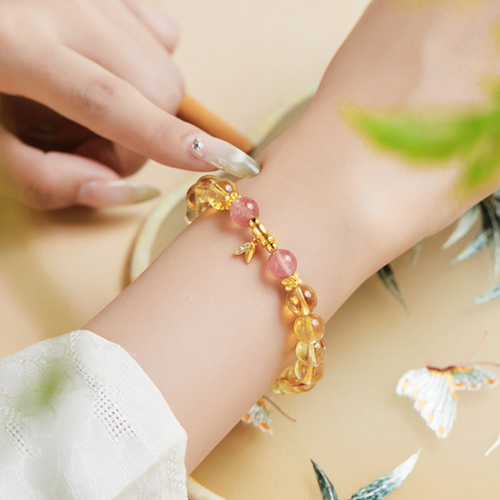 Bamboo citrine bracelet worn on the wrist with pink bead accents
