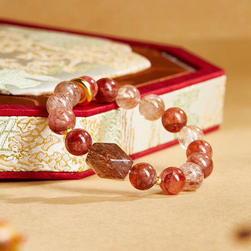 Diamond shaped crystal focal bead beside red quartz and gold peace roundel