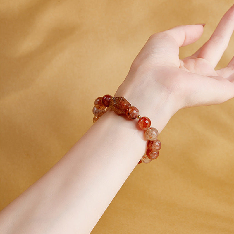 Original model wearing the elastic crystal bracelet against a warm golden backdrop