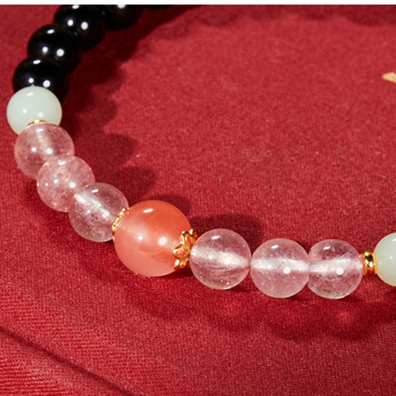Close product view of the bracelet's nephrite jade, strawberry quartz, and South Red agate bead sequence