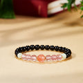 Hero image of black obsidian and South Red agate stretch bracelet