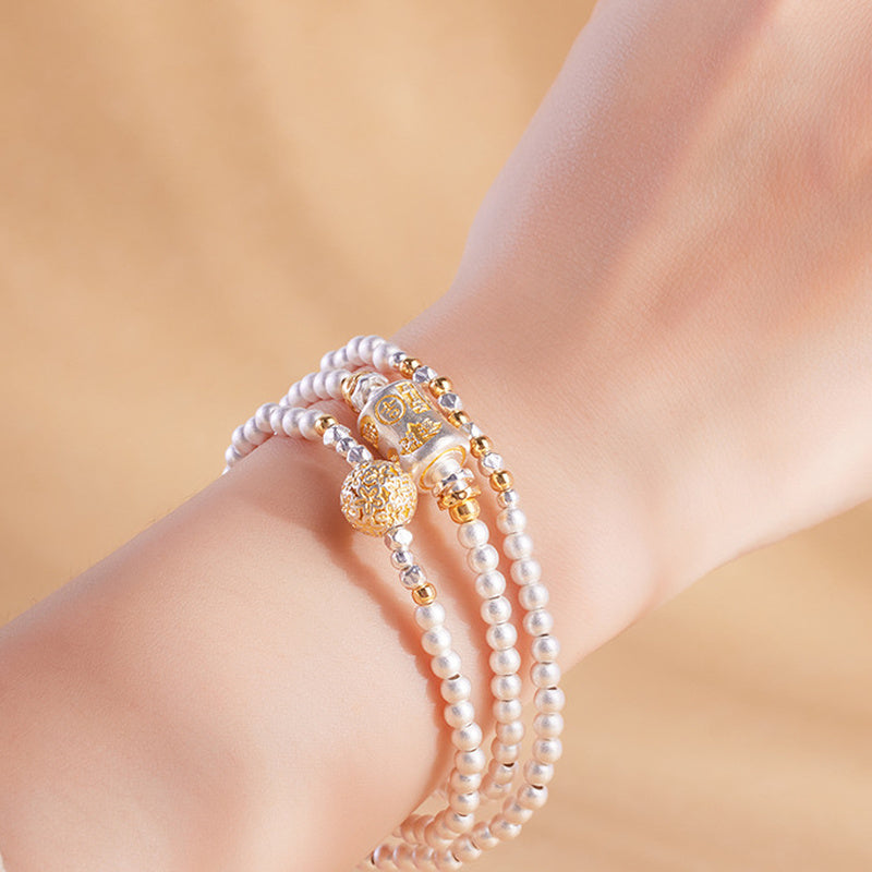 Triple wrap silver bracelet with blessing barrel worn on wrist