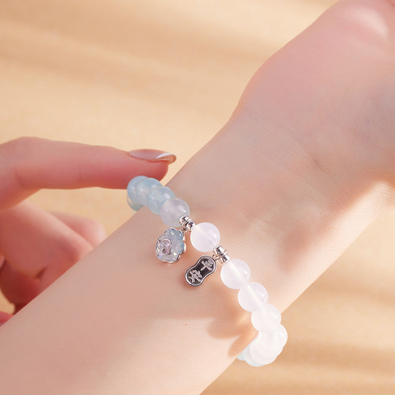 Woman wearing blue agate and white chalcedony charm bracelet