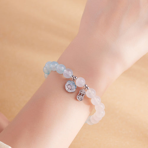 Wrist detail of pale blue agate and white chalcedony bracelet