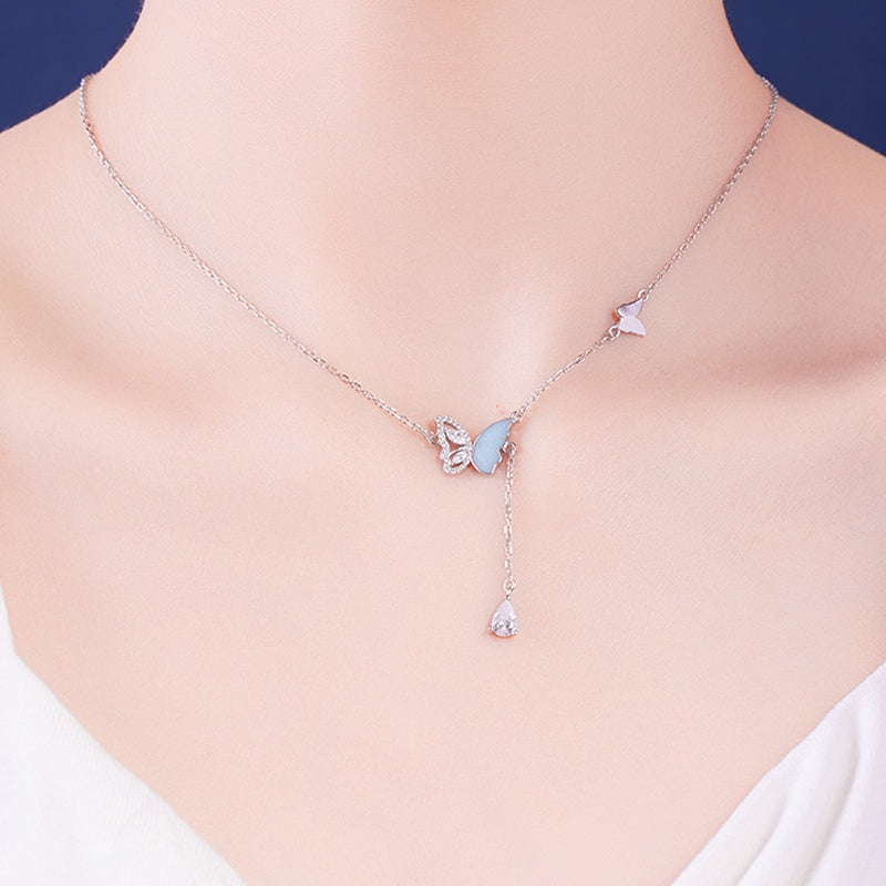 Original model wearing the silver butterfly necklace with blue enamel wing