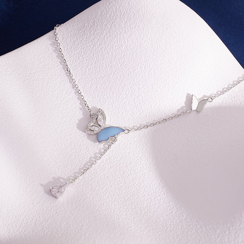 Angled view of the blue enamel butterfly and silver chain tassel