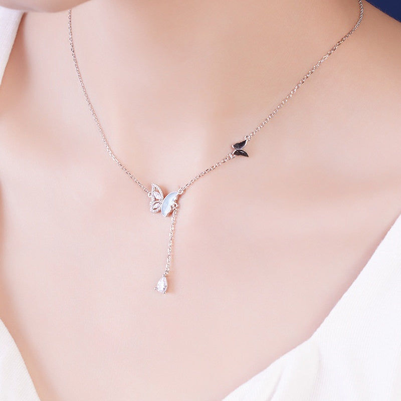 Supplier model wearing the butterfly necklace above a white neckline