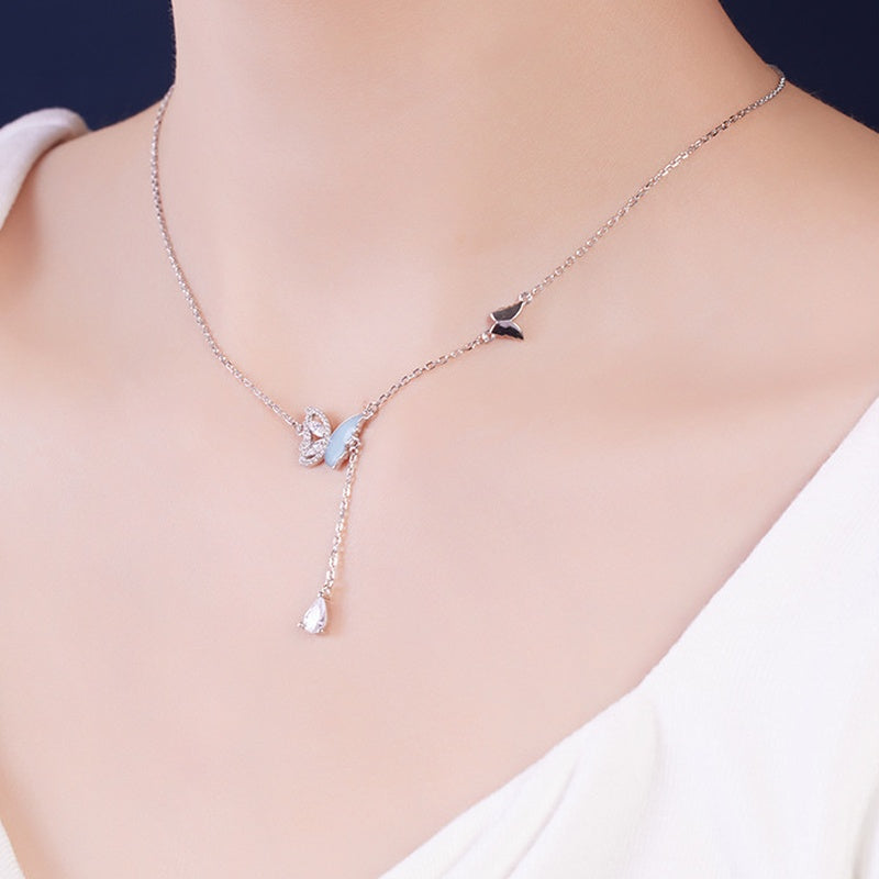 Side view showing the butterfly necklace and delicate teardrop tassel