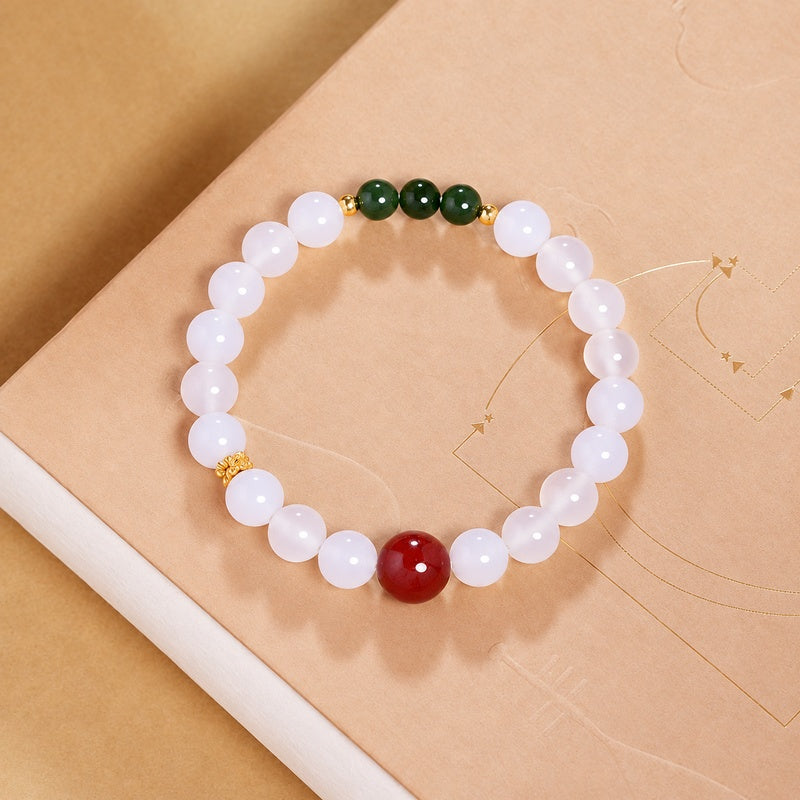 Overhead view of white chalcedony bracelet with red cinnabar and green jade