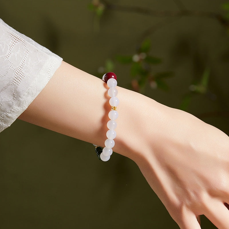 Side wrist view showing white chalcedony beads and a red cinnabar accent