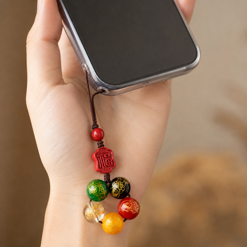Woman holding phone with cinnabar five-element agate charm attached