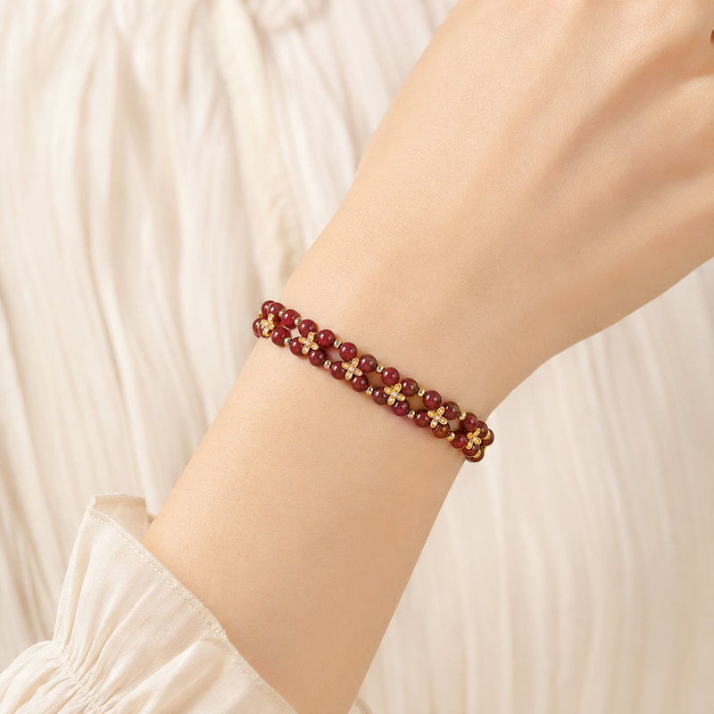 Cinnabar clover double-strand bracelet worn on a woman's wrist