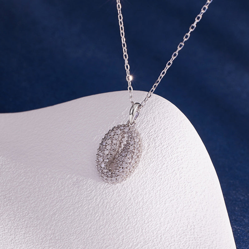 Angled view of pavé coffee bean pendant necklace