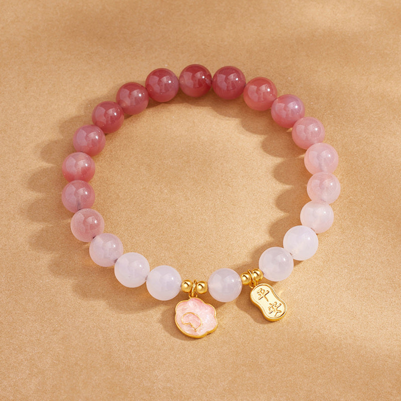 Gradient crimson agate bracelet top view with two charms