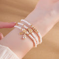 Fine Silver 999 gourd triple-wrap bracelet worn on wrist against sand