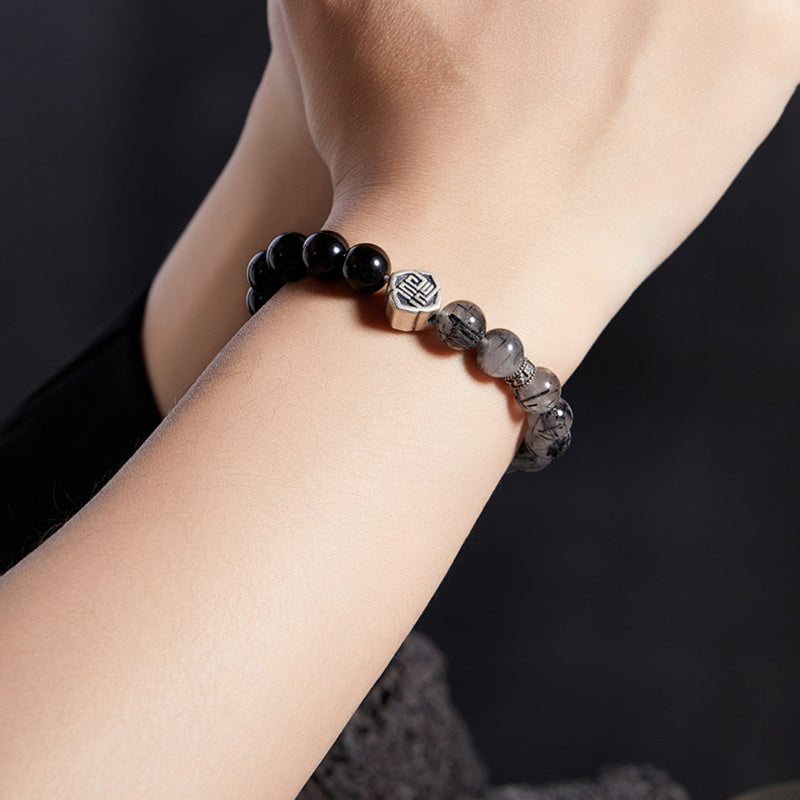 Close wrist view of Fu symbol gemstone bracelet