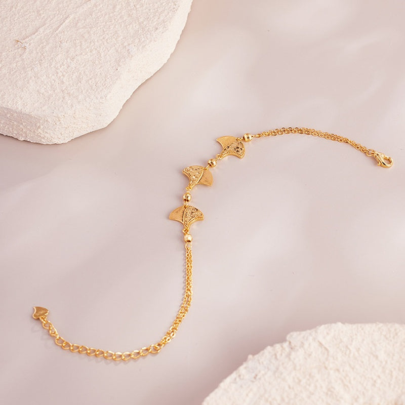 Open ginkgo leaf bracelet with clasp and extender on blush fabric