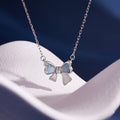 Gradient enamel bow necklace on sculpted white fabric